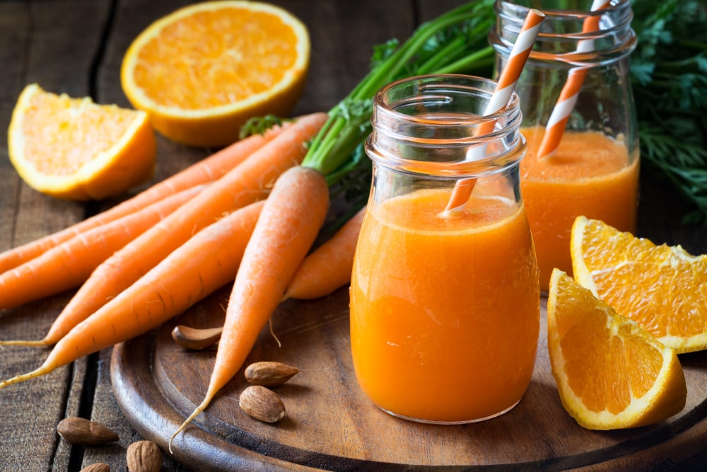Čerstvé pomerančové smoothie s mrkví ve sklenici s brčkem